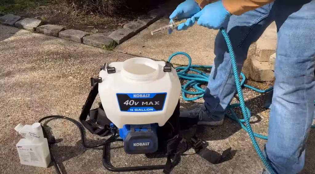 Technician assembling spraying equipment, showcasing preparation for pest control services in Phenix City.